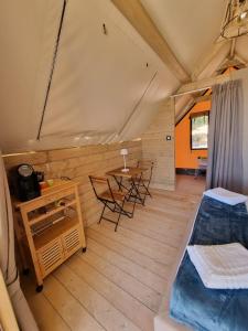 a room with a table and chairs in a tent at Casa Sgarlata Glamping - Tenda Palma Nana in Cava dʼAliga