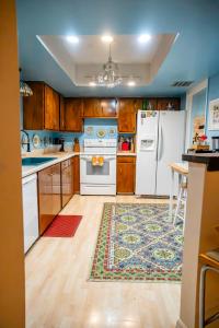 a kitchen with white appliances and a rug at Bohemian Bungalow in Port Saint Lucie