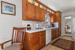 una cocina con armarios de madera y un aparato blanco en Holly Hill Cottage, en Cambria 21 fotos más