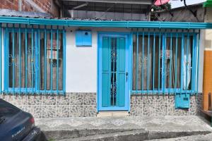a blue door on the side of a building at Hospedaje del Cafe Salento in Salento
