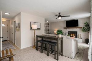 a living room with a couch and a table with a fireplace at Central Family Oasis with Hot Tub & Fenced Yard in Omaha +71 photos