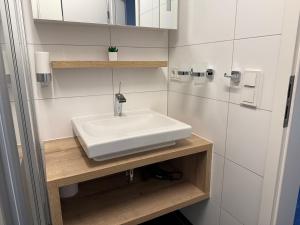 a bathroom with a white sink and a shower at Ferienhaus Lakoma in Elsterheide +9 photos