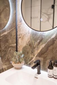 a bathroom sink with a mirror and a plant at Amber Corner I Brand New Flat Top Location in Sofia