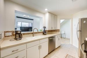 a kitchen with white cabinets and a sink and a window at Pool and Trail Access On-Site Barton Creek Condo! in Austin +19 photos