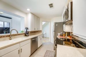 a kitchen with white cabinets and a stainless steel refrigerator at Pool and Trail Access On-Site Barton Creek Condo! in Austin