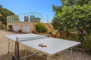 un tavolo da ping pong con un paio di forbici sopra di Villa Caroline by Villa Plus a Thèzan-lès-Béziers