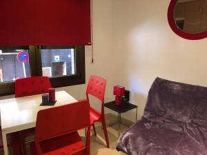 a room with two red chairs and a table and a window at Sky 101 by Confortsky in Pas de la Casa