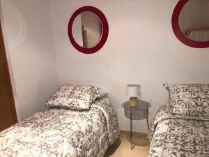 a bedroom with two beds and a mirror on the wall at Sky 101 by Confortsky in Pas de la Casa