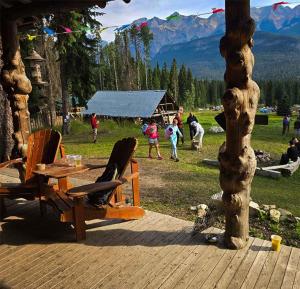 a wooden deck with chairs and a table and people at Rustic Beaverfoot Lodge Room N4 in Parson