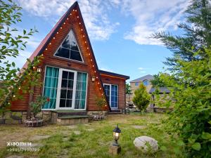 a small house with a pointed roof on a yard at Quba A-Frame near Lake & Forest 1 in Quba