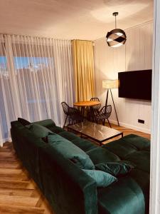a living room with a green couch and a table at Sea Spray Nida in Nidden