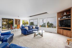 a living room with blue couches and a tv at Snug Harbor in Cambria