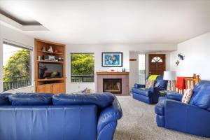 a living room with blue couches and a fireplace at Snug Harbor in Cambria