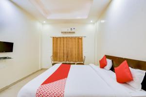 a bedroom with a large bed with red pillows at Hotel O The Thar Mid Way Hotel And Restaurant in Jodhpur