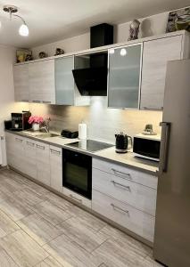 a kitchen with white cabinets and stainless steel appliances at Pokoje Gościnne Nowa Grań in Zakopane