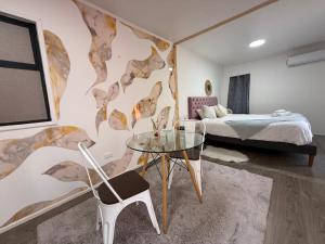 una camera con un tavolo in vetro e un letto di Beehouse Withe Jacuzzi Opcional a Villa Alemana