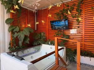 bagno con vasca e TV a parete di Beehouse Withe Jacuzzi Opcional a Villa Alemana