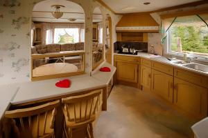 a kitchen with wooden cabinets and a sink at Domek angielski in Białowieża