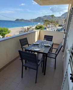 een tafel op een balkon met uitzicht op het strand bij FAMILY HOUSE Letojanni Taormina in Letojanni