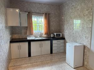 a kitchen with white cabinets and a white refrigerator at Garnizoenspad appartementen in Baskamp