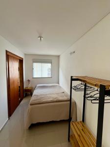 ein Schlafzimmer mit einem Bett und einem Fenster in der Unterkunft Casa prox. a praia do Campeche in Florianópolis