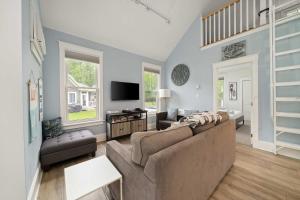 a living room with a couch and a tv at The Tamarack - 11 Hollow in Cherry Valley