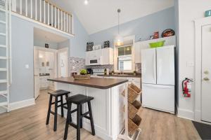 a kitchen with white cabinets and a island with stools at The Tamarack - 11 Hollow in Cherry Valley +62 photos