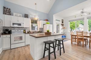 a kitchen with white cabinets and a table and chairs at The Tamarack - 11 Hollow in Cherry Valley
