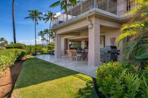 una casa con patio arredato con tavolo e sedie di 2BD Hillside Villa (4102) at Hualalai Resort a Kukio