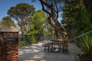 a row of tables and chairs on a patio at Tree Top - Perfect Apartment For Relaxing Getaway, Balcony, Parking in Lynmouth
