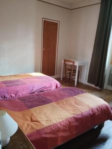 a bedroom with two beds and a table and a chair at Poterie d'Art in Embrun