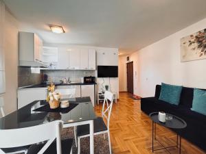una cucina e un soggiorno con un tavolo e un divano di Azure a Vrnjačka Banja