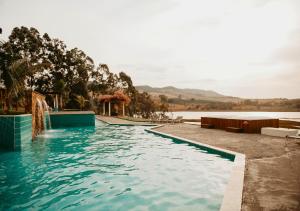a swimming pool with a view of a body of water at Hotel Chalé Capitólio in Capitólio