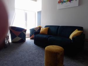 a living room with a blue couch and a stool at 5 Prospect Place - 2nd floor Dream View in Scarborough