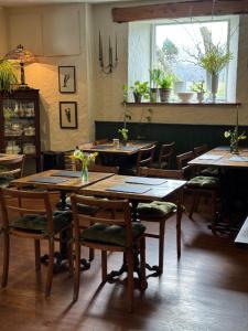 a restaurant with wooden tables and chairs and a window at The Bellachroy Hotel in Dervaig