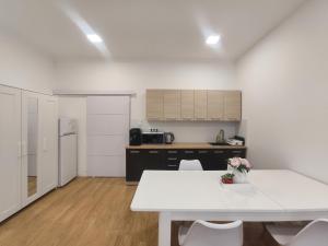 a kitchen with a white table and white chairs at Ruyi holiday -Családi ház in Sopron