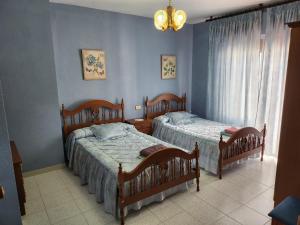 2 Betten in einem Schlafzimmer mit blauen Wänden in der Unterkunft La Casa de las Golondrinas in Santisteban del Puerto