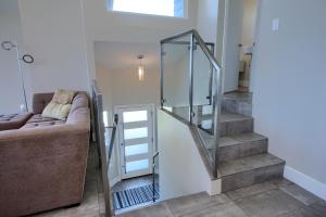 a glass staircase in a living room with a couch at Cambria Park Shores in Cambria