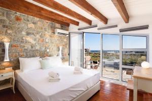 キオタリにあるVilla Beatris Seastone by Villa Plusの石壁のベッドルーム1室(大きな白いベッド1台付) +12枚の写真
