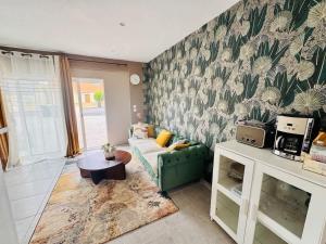 a living room with a couch and a table at Loft Bis cosy proche des plages et villes in Démouville