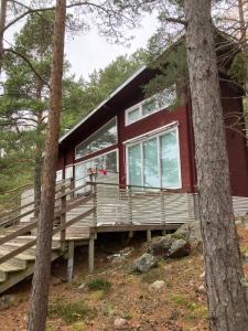 a red cabin in the woods with trees at Nauvo Valmu in Valmoholm