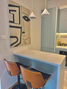 a kitchen with a counter with two chairs and a table at Donna Apartment by Sienna in Skopje