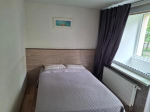 Ένα ή περισσότερα κρεβάτια σε δωμάτιο στο Apartamentai Dana