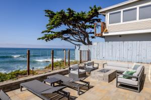 een terras met stoelen en tafels en de oceaan bij Oceanfront Stella Maris in Cambria