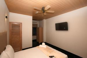 une chambre avec un ventilateur de plafond et une télévision au mur dans l'établissement Casa Santa Cruz & Social Coffee, à Carthagène des Indes