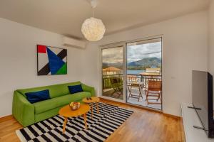 a living room with a green couch and a table at Chill Zone in Tivat