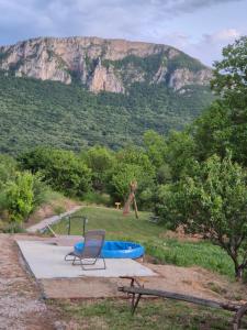 a chair and a blue tub in front of a mountain at Konak -Guest house -Ramonda Serbika in Niš
