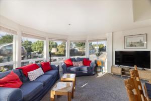 a living room with a blue couch and a tv at Casa De Marina in Cambria