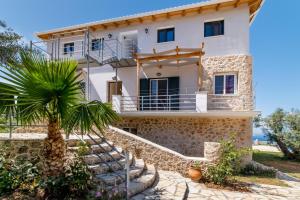 a house with a palm tree in front of it at Apartment with Sea view B in Tsoukaladhes