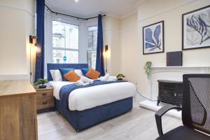 a bedroom with a blue bed and a fireplace at The Bay View Stays - 2 Sleek Apartments by Parydise - Great for Families & Professionals in Morecambe